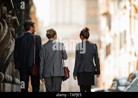 Young business colleagues walking down an urban street. Stock Photo