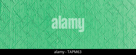 Green textured wall detail. Abstract retro decor with pattern from diagonal scratches. Wide-angel nostalgic background from embossed stucco plaster. Stock Photo