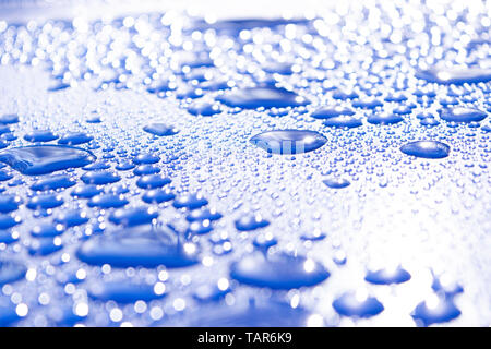 Transparent still water drops on light blue background. Blue water drops. Drops of rain on glass. Blue abstract water drop background. Water surface Stock Photo