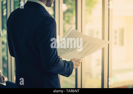 Business contractor is checking out construction plan Stock Photo