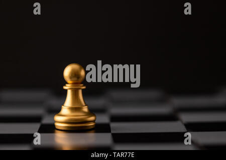 gold chip on the chessboard and black background Stock Photo