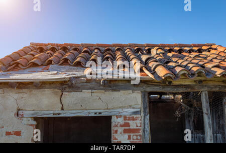 Broken brick on the roof of a cottage. Damaged roof. Stock Photo