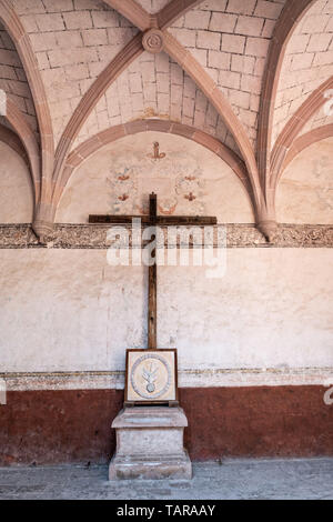 Wooden cross in the courtyard hall at the San Nicolas Tolentino Temple and Ex-Monastery in Actopan, Hidalgo, Mexico. The colonial church and convent  was built in 1546 and combine architectural elements from the romantic, gothic and renaissance periods. Stock Photo