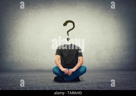 Surreal headless guy, invisible face seated on the floor with a question mark instead of head, like a mask, for hiding identity. Interrogation sign sy Stock Photo