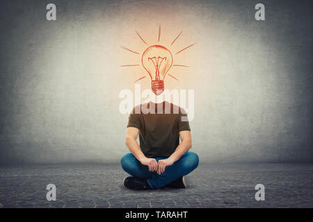Surreal headless guy, invisible face seated on the floor with a glowing lightbulb instead of head, as an idea and inspiration symbol. Bulb as genius m Stock Photo