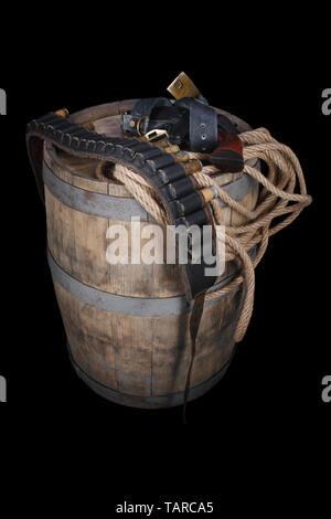 Old wild west gun with cartridges and gunbelt on wooden barrel Stock Photo