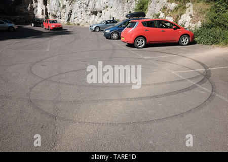 May 2019 - Car tyre skid marks left by bored teenagers in Cheddar Gorge car park Stock Photo