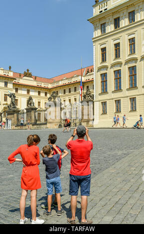 PRAGUE, CZECH REPUBLIC - JULY 2018: Members of a family taking pictures outside the entrance to Prague Castle. Stock Photo