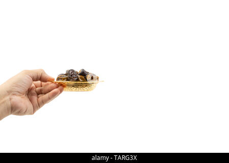 Hand holding dried dates fruits isolate on white. Selective focus Stock Photo