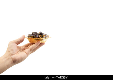 Hand holding dried dates fruits isolate on white. Selective focus Stock Photo