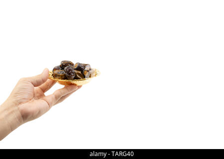 Hand holding dried dates fruits isolate on white. Selective focus Stock Photo