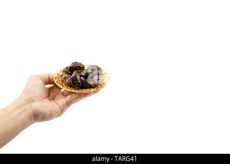 Hand holding dried dates fruits isolate on white. Selective focus Stock Photo