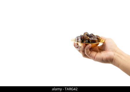Hand holding dried dates fruits isolate on white. Selective focus Stock Photo