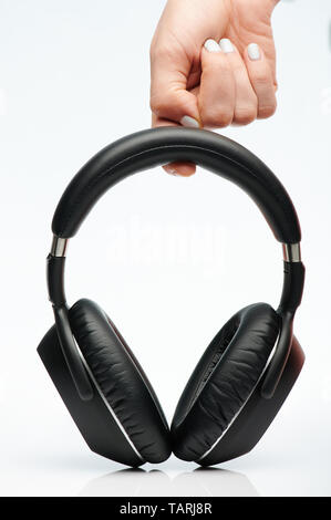 Hand hold black headphones isolated on white background Stock Photo