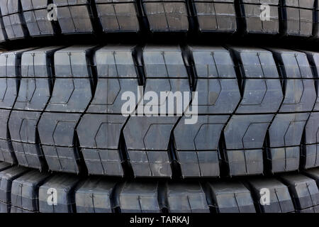 Extra large sized coal mining truck tires, new industrial black rubber tires with unique tread patterns Stock Photo