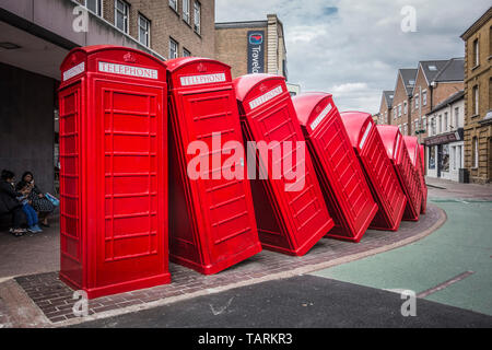 David Mach's row of 'Out of Order' red tumbling telephone boxes on Old London Road, Kingston Upon Thames, Surrey, UK Stock Photo