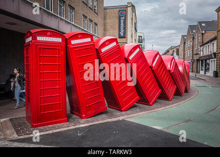 David Mach's row of 'Out of Order' red tumbling telephone boxes on Old London Road, Kingston Upon Thames, Surrey, UK Stock Photo