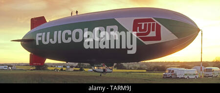 Fuji airship blimp at aerodrome airfield 1980s ground crew vans during advertising flights over London for Fujicolor film products Essex England UK Stock Photo