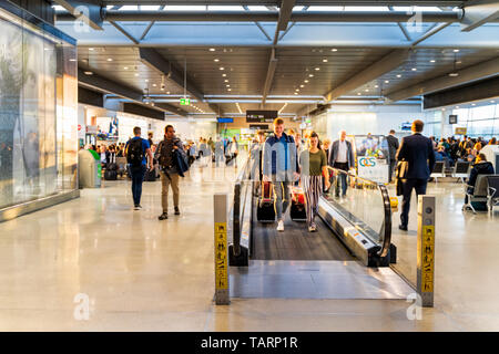 Dublin, Ireland, May 2019 Dublin airport, people rushing for their flights, departure hall with moving walkway, motion blur Stock Photo