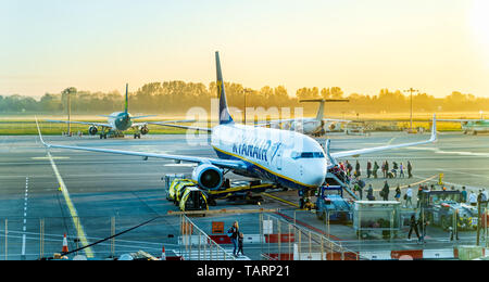 Dublin, Ireland, May 2019 Dublin airport, people boarding airplane, airfield with multiple aircraft, sunrise and early hour mist Stock Photo