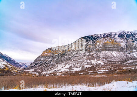 Striking mountain with scattered trees on its snow covered slope Stock Photo