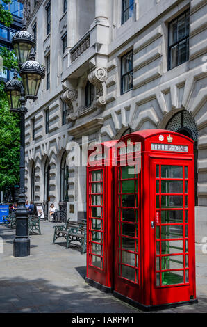 A couple of traditional red telephone boxes stand on Royal Exchange in London, UK. Stock Photo