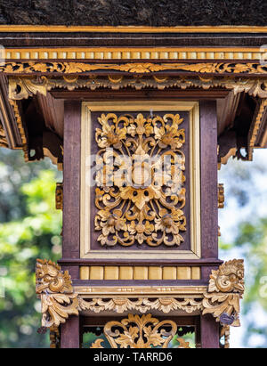 Dusun Ambengan, Bali, Indonesia - February 25, 2019: Clan compound. Closeup of golden decoration square on one of the memorials for ancestors. Stock Photo