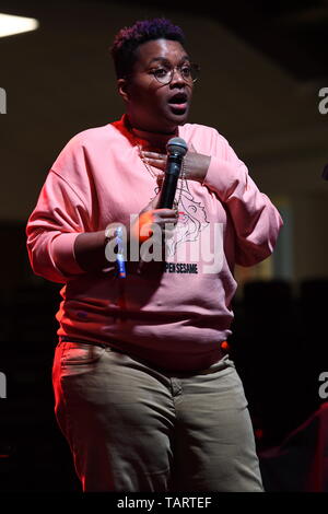 Comedian Sam Jay is shown performing on stage during a 'live' stand up concert appearance. Stock Photo