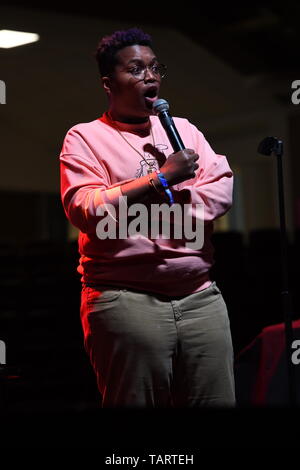 Comedian Sam Jay is shown performing on stage during a 'live' stand up concert appearance. Stock Photo