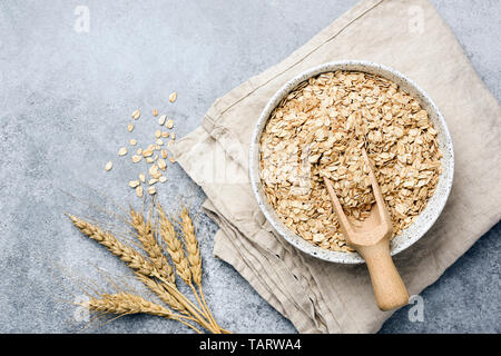 Oat flakes, oats or rolled oats in bowl. Table top view Stock Photo