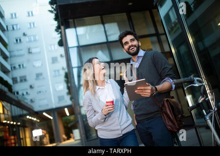 Beautiful young couple walking down the street with tablet Stock Photo