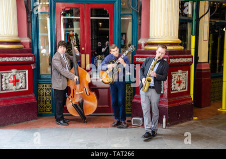 A three piece jazz group play in the Leadenhall Market in the financial district of the The City of London, UK Stock Photo