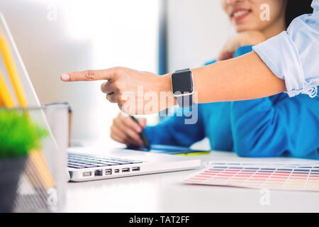 Creative or Interior designers teamwork with pantone swatch and building plans on office desk, architects choosing color samples for design project on Stock Photo
