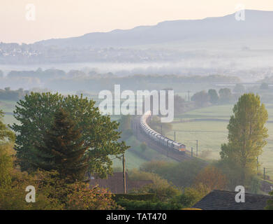 GB Railfreight class 66 locomotive near Skipton on a misty morning hauling a freight train carrying aggregates Stock Photo