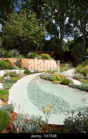 RHS Chelsea Flower Show 2019: the Dubai Majlis Garden designed by Thomas Hoblyn, included drought-tolerant plants, a water feature and adobe retaining walls. Stock Photo