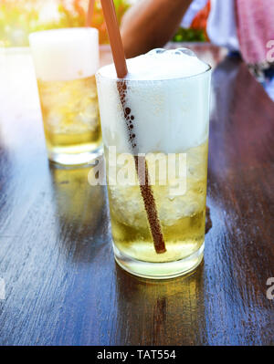 bubble froth in glass beer mug with drinking straws on table Stock Photo