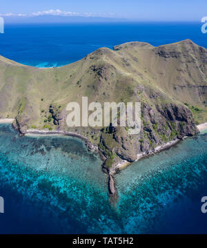 Seen from a bird's eye view, the blue Pacific Ocean surrounds the rugged island of Gili Banta, just outside of Komodo National Park in Indonesia. Stock Photo