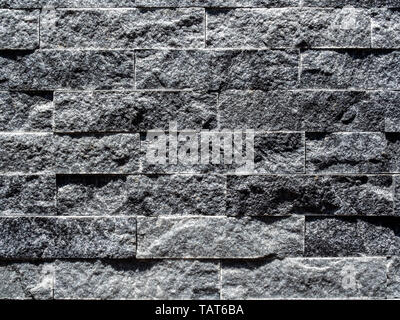 Close-up modern grey brick wall background. Grey stone brick tiles texture. Stock Photo