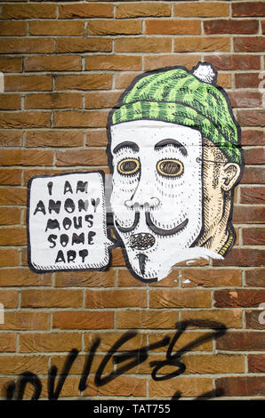 LONDON, UK - MARCH 19, 2016: Arty graffiti using the Anonymous trope on a wall on the trendy Fish Island, Hackney in the East End of London. Stock Photo