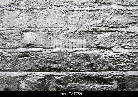 A brick wall sprayed with silver paint. Stock Photo