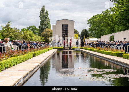 US Memorial Day remembrance event at Cambridge American Cemetery and Memorial, Cambridgeshire, UK. Memorial building and Reflecting Pool. People Stock Photo