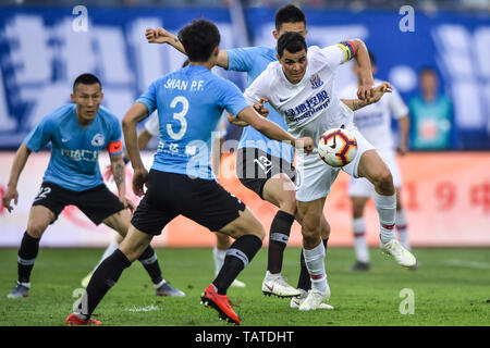 Colombian football player Giovanni Moreno, right, of Shanghai Greenland Shenhua passes the ball against players of Dalian Yifang in their 11th round match during the 2019 Chinese Football Association Super League (CSL) in Dalian city, northeast China's Liaoning province, 25 May 2019.  Dalian Yifang defeated Shanghai Greenland Shenhua 1-0. Stock Photo