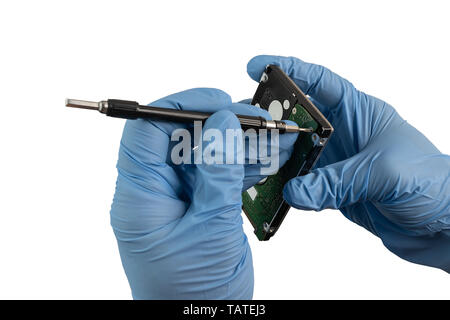 A hand with glove unscrews a hard disk with a screwdriver Stock Photo