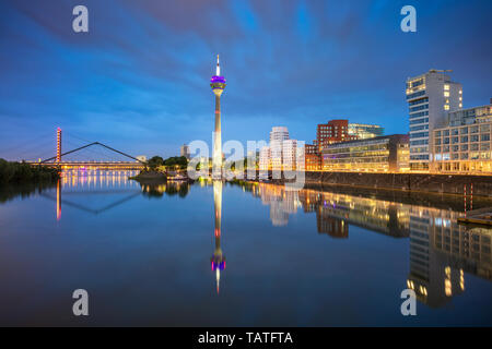 Dusseldorf, Germany. Cityscape image of Düsseldorf, Germany with the Media Harbour and reflection of the city in the Rhine river, during twilight blue Stock Photo