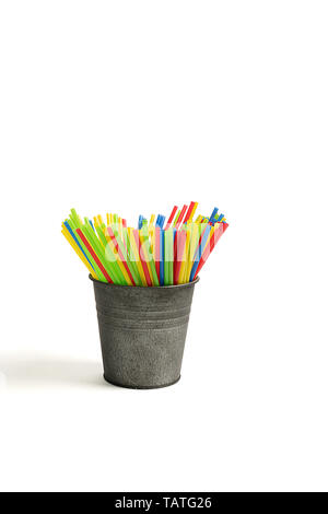 Straws of different colors in a metal bucket on white background Stock Photo