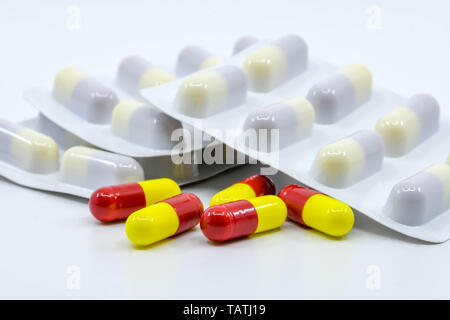 CARDIFF, WALES - MAY 2019: Close up view of coloured capsules of cold and flu medication with more capsules in plastic sleeves, Stock Photo