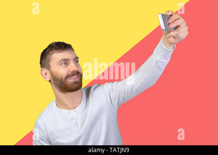 Cheerful young man making photo of himself Stock Photo