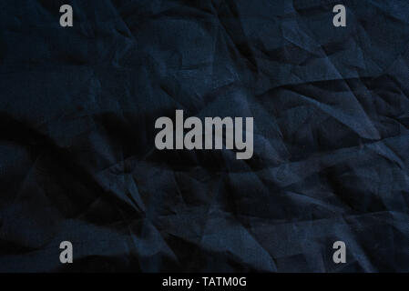 Macro of the texture of a wrinkled plastic fabric of black color, background for designs. Stock Photo