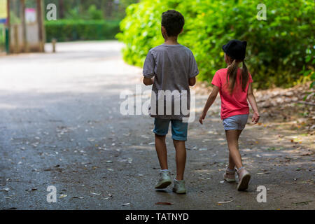 Friendly boys and girls. brother sister walk in the park, rear view Stock Photo