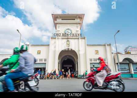 Ho Chi Minh City, Vietnam - April 8, 2019: the facade of Ben Thanh Market with a group of blonde girls and street traffic blurred in motion. Stock Photo
